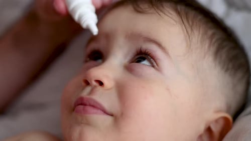 baby kid child boy taking eye drop, conjunctivitis treatment 4k close up.