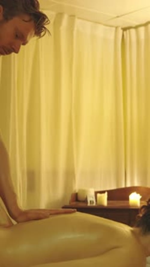 Man Giving Woman Relaxing Massage in Spa Setting
