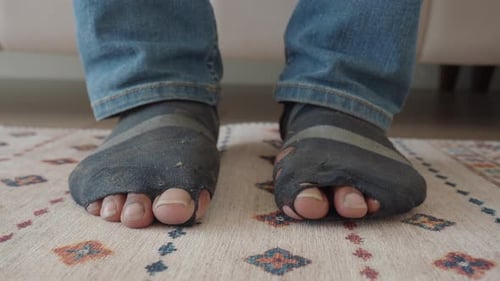 Hole Filled Socks Standing on Intricate Rug