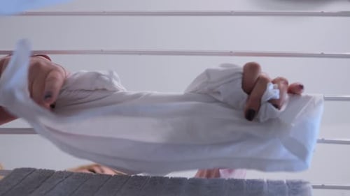 Woman hanging linen from washing Slow motion view from below