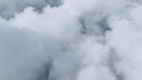 Luftaufnahme Wolkenbedeckte Berggipfel und ein ruhiger Wald darunter