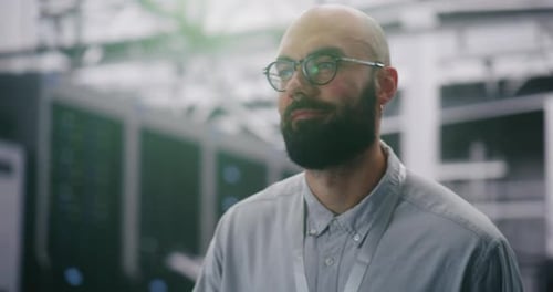 Man in Server Room Wearing Glasses and Badge