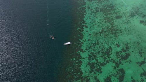 Peaceful longtail boats rest on bright coastal water, Thailand