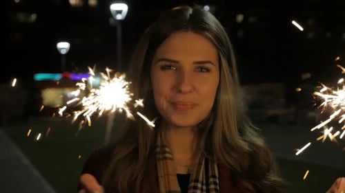 Woman Smiling, Waving Sparklers on Winter Night