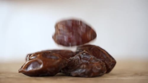 Close up of Dried Date Fall into Pile, White Background with Copy Space