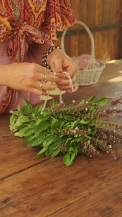 Uma mulher envolvida na elaboração de um lindo buquê de ervas usando vários elementos naturais