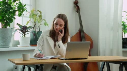 Woman Working From Home with Phone and Laptop