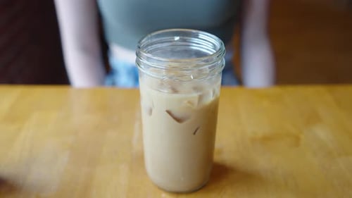 Iced coffee in a glass mason jar cup. Iced coffee at a cafe in a glass cup. Repurposing a glass jar