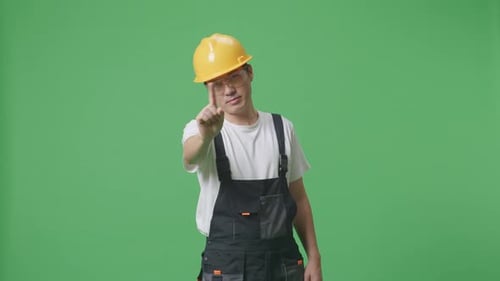 Man Worker Wearing Safety Helmet Pointing And Disapproving With No Index Finger Sign On Green Screen
