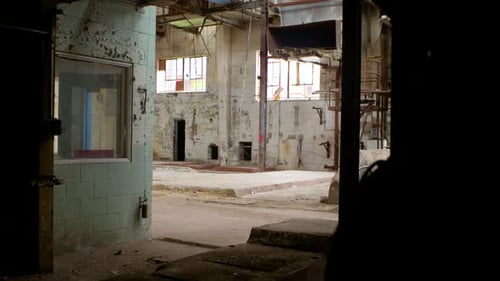 A pan from left to right from the perspective of the doorway of an abandoned factory.
