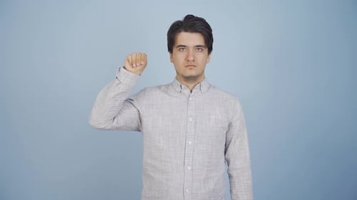 Young Adult Man Gesticulating Hand Against Blue Backdrop