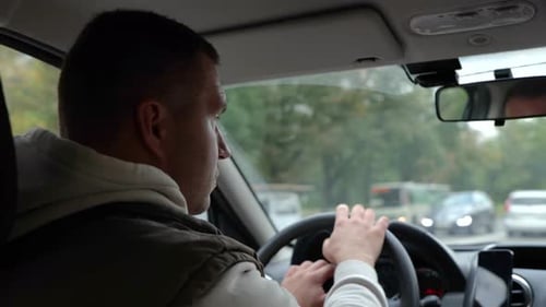 Nahaufnahme eines erwachsenen kaukasischen Mannes, der auf der Autobahn ein Auto fährt und von Seiten schaut
