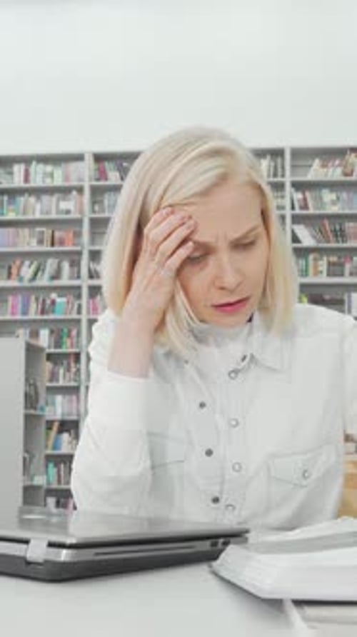 Stressed Female Student Studying Intensely at the Library