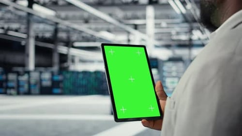 IT-Experte für Rechenzentren verwendet ein Mockup-Tablet, um die Leistung der Geräte in Nahaufnahme zu überprüfen