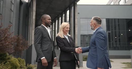 Business Professionals Shaking Hands Outside Office Building