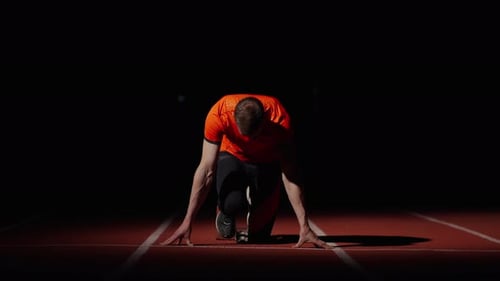 Professional Runner Standing On Start And Starting On Sprinter Lane Epic Frontal Shot In Darkness