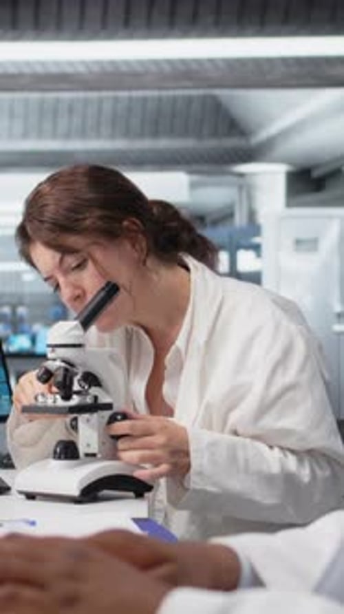 Vertical Video Clinical Lab Technologist Uses Scientific Microscope for Disease Detection