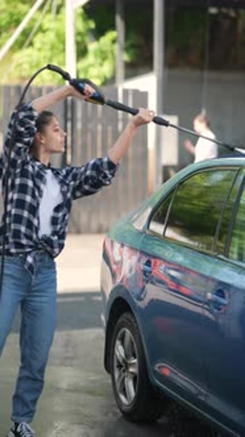 The Car Wash Scene Captures a Girl in High Spirits As She Washes Her Car with a Foam Gun
