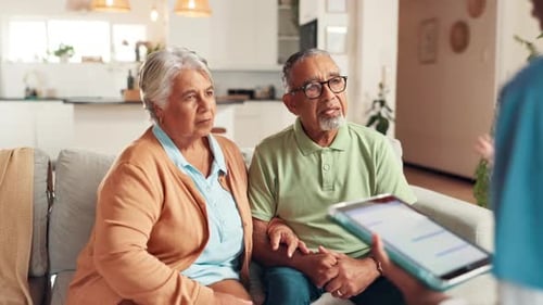 Senior Couple Consults Healthcare Worker With Tablet