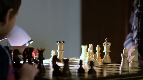Großmutter spielt zu Hause mit ihrem Enkel Schach, Nahaufnahme, Zeitlupenaufnahmen, gedrehtes Video