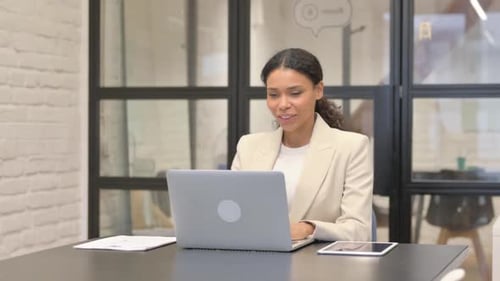 Woman using laptop during a video conference in office