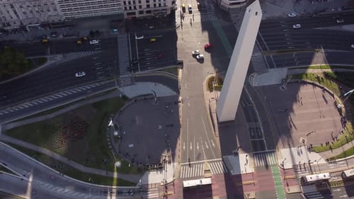 Aerialo orbit shot of famous Obelisco Obelisk Monument in Buenos Aires with traffic during sunset