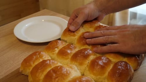 Golden Pull Apart Rolls Being Placed on Plate
