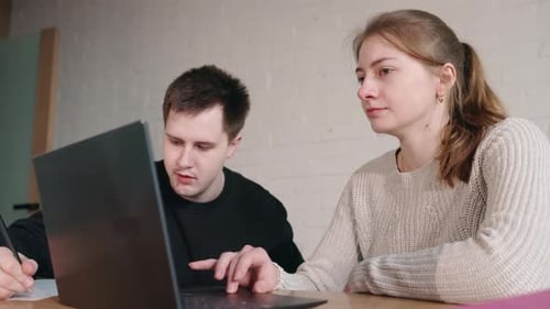 Young Adults Working Together on Laptop Indoors