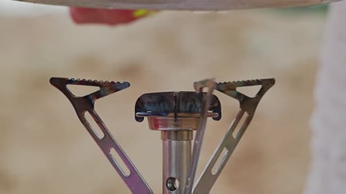 Close Up Woman Places Pan on Gas Burner During Camping Cooking Outdoors