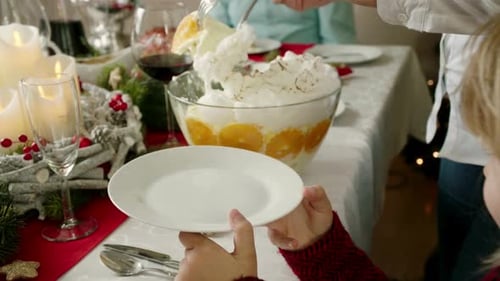 Child Receives Dessert from Adult at Holiday Table