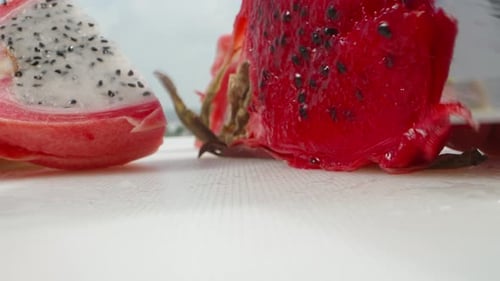 Pitahaya or dragon fruit with red flesh, I cut a piece with a knife. Super close-up.