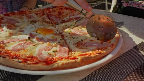 Slicing delicious fresh pizza in restaurant, close up view