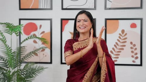 Smiling Woman Clapping in Front of Framed Art