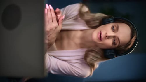 Smiling Woman Video Calling with a Laptop and Headphones