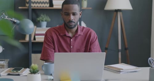 Young Man Working at Desk on Laptop