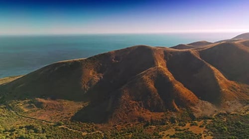 Stunning scenery of mountains locating near the ocean. Drone rising footage over the rocks