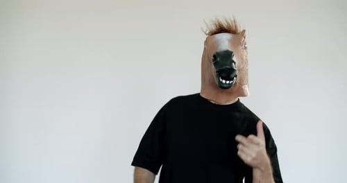 Adult in Horse Mask Gesticulates and Dances