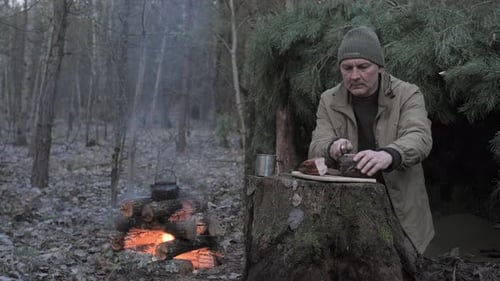 Man Preparing Rustic Meal at Forest Campsite