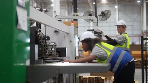 Engenheiros trabalhando com equipamentos de máquinas na fábrica