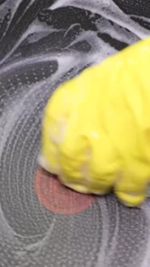 A Woman's Hand Washes a Pan in the Sink in the Kitchen Room Vertical Video