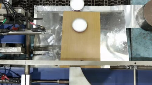 Bottle Caps Moving On Cap Lining Conveyor At Industrial Factory. overhead shot