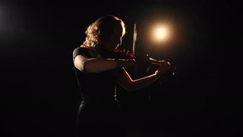 Female Violinist Performing in a Dark, Dramatic Setting