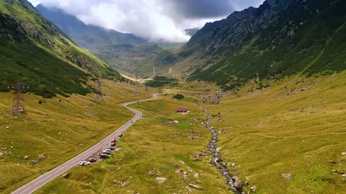 Flight over the wavy highway and river passing through the valley.