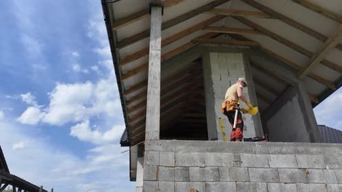 Construction Worker Working on Side of House