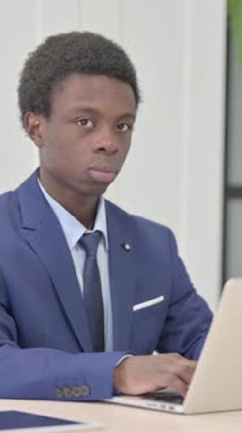 Focused Young Man Working on Laptop in Office
