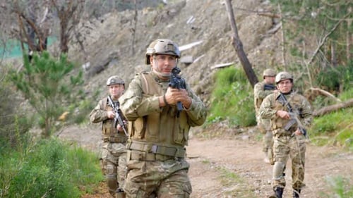 Front view of Biracial military soldiers rifle training in fields during military training 4k