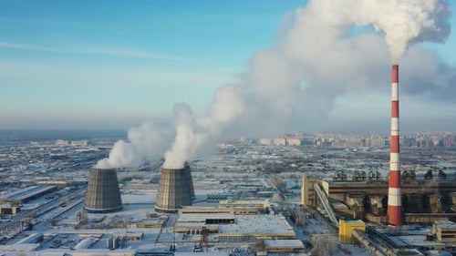 Industrial Landscape with Steam and Smoke Rising Against a Clear Blue Sky in Winter