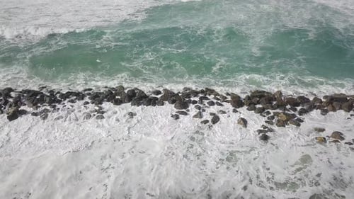 Waves Crashing on Rocky Shore From Aerial View