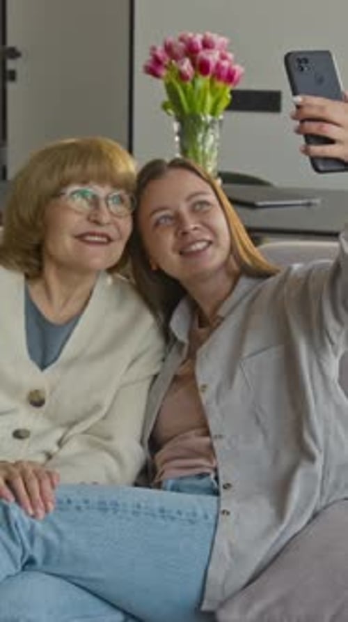 Women Take Selfie Together on Sofa at Home