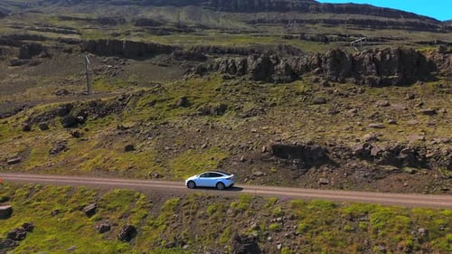 Car Travels on Rural Road Through Mountain Landscape